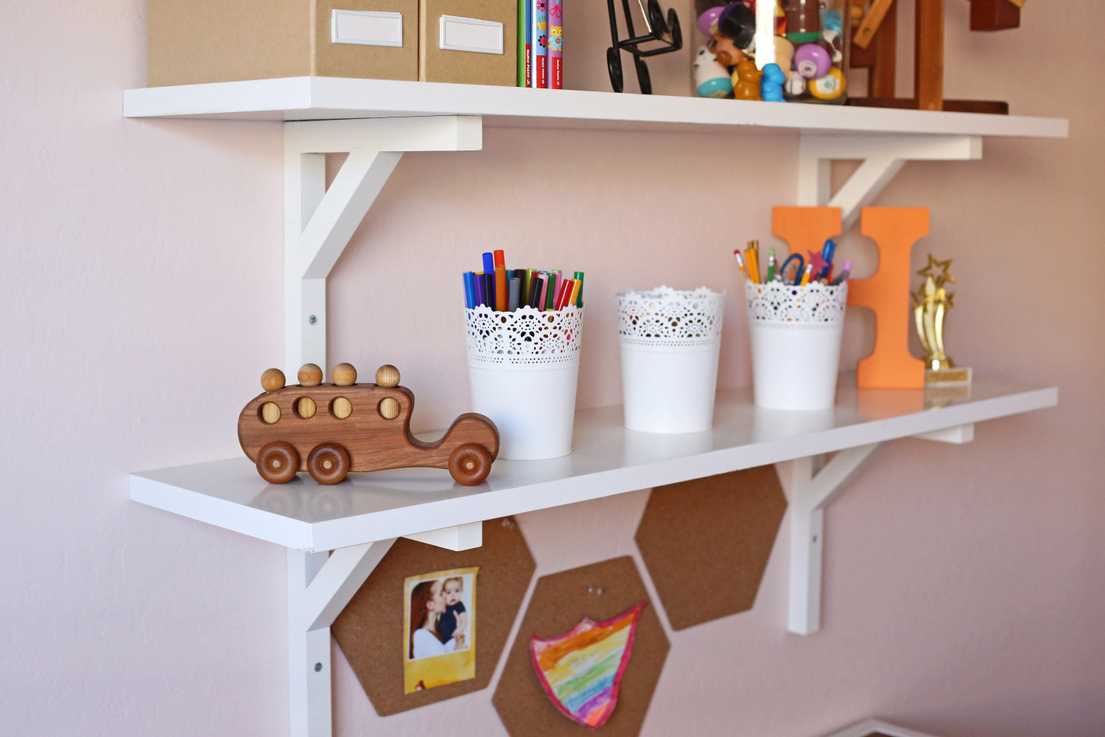 A light pink little girl's room with gold, wood, and coral accents A light pink little girl's room with gold, wood, and coral accents
