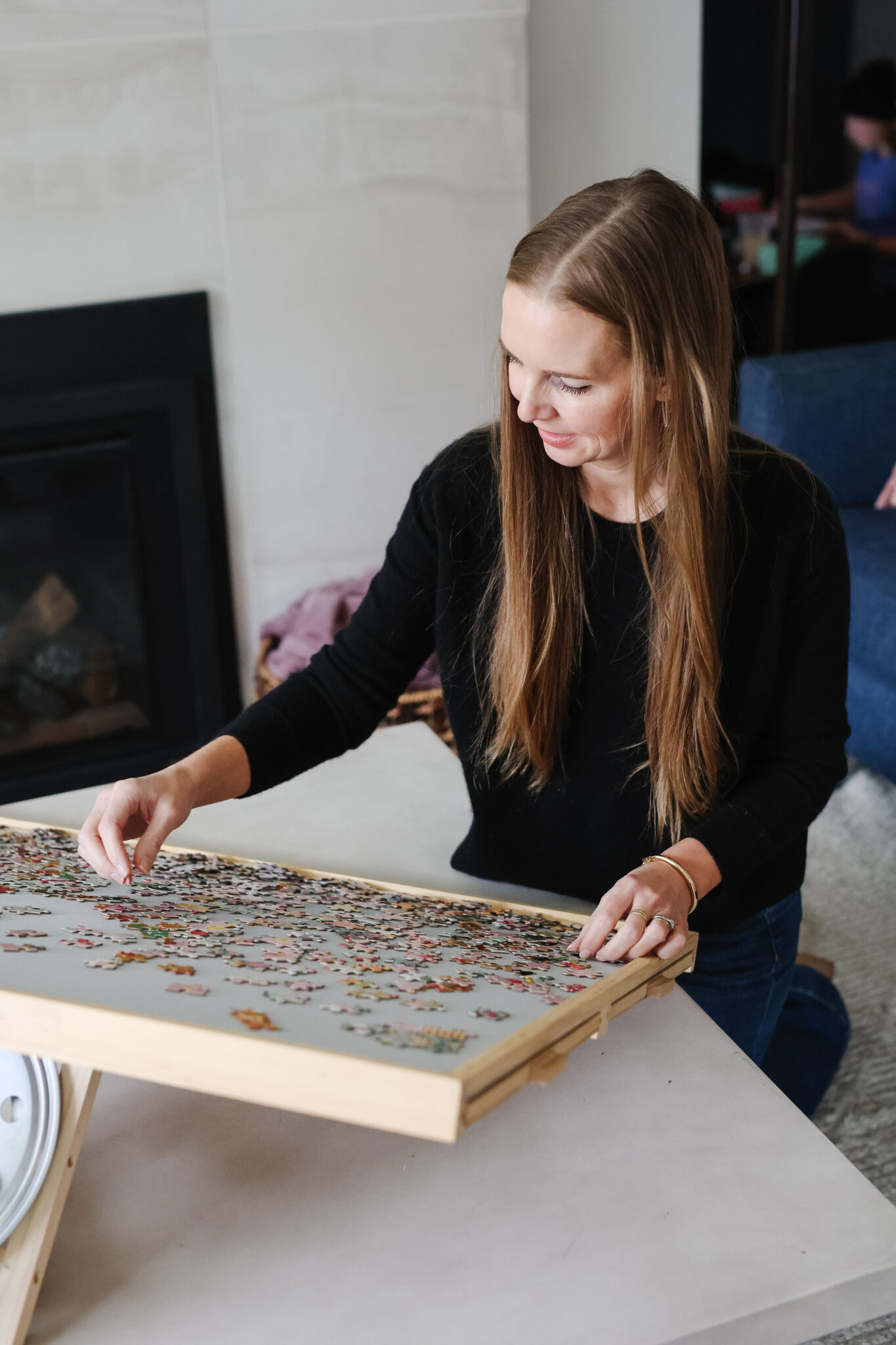woman doing a puzzle on a puzzle board