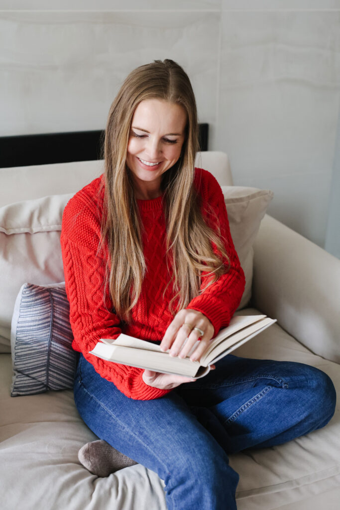 woman in red sweater reading a book
