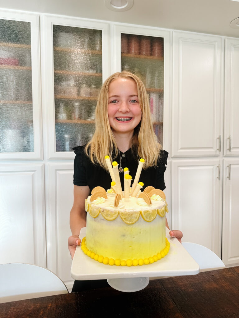 teen girl holding her yellow lemon birthday cake